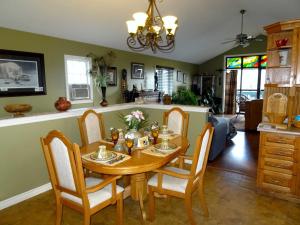 uma cozinha e sala de jantar com uma mesa de madeira e cadeiras em Safari Getaway em Orono