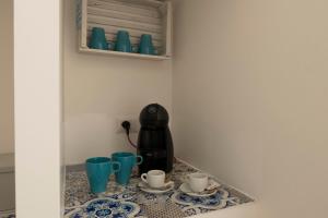 a coffee maker on a counter with cups on it at estea in Castellaneta Marina 