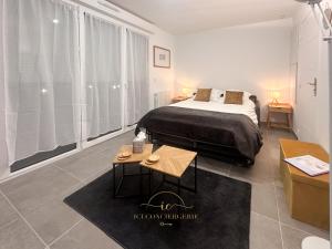 a bedroom with a bed and a large window at Le Jardin Rambolitain - Terrasse et Parking in Rambouillet