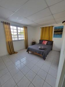 ein Schlafzimmer mit einem Bett in einem Zimmer mit gelben Vorhängen in der Unterkunft MF Vacation Homes Villa 2 in Loiza
