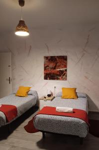 two beds with yellow and red pillows in a room at SevillaDream in Seville