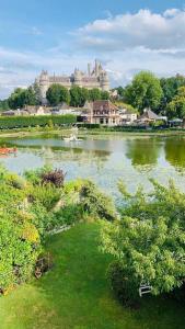 un grand lac avec un château en arrière-plan dans l'établissement Maison de charme avec vue sur château, à Pierrefonds