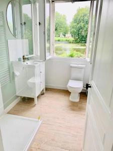 ein weißes Bad mit einem WC und einem Fenster in der Unterkunft Maison de charme avec vue sur château in Pierrefonds