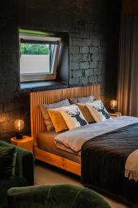 um quarto com uma cama com almofadas e uma janela em Briežu Kūts em Mustkalni