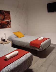 a room with two beds and a tv on the wall at SevillaDream in Seville