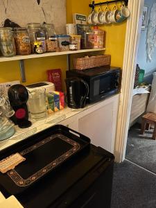 a kitchen with a counter with a microwave on it at Large Room sleeps 3 own TV and cereal and toast breakfast in Newhaven in Tarring Neville