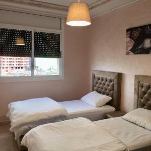 een kamer met 2 bedden en een raam bij Luxury Apartment II Nador Jadid Free Parking & Wifi in Nador