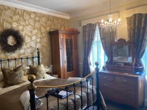 een slaapkamer met een bed, een dressoir en een raam bij Heathfield Bed and Breakfast in Whitby