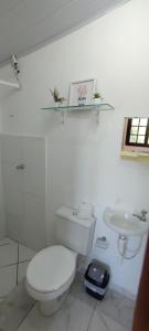 uma casa de banho branca com um WC e um lavatório em Chalé Mirante do Félix - Suíte Laranja em Ubatuba