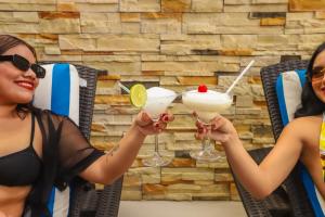 two women holding cocktails in their hands at Hotel Pejelagarto in Bacalar