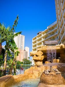 
a large pool of water surrounded by palm trees at Hotel Servigroup Orange in Benidorm
