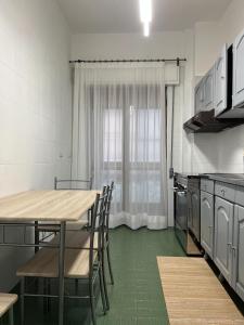 a kitchen with a table and chairs and a window at Gelsi Apartment - Roma Metro C in Rome