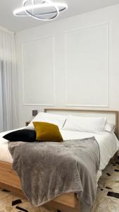 a bedroom with a bed with a yellow pillow at Gelsi Apartment - Roma Metro C in Rome
