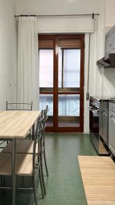 a kitchen with a table and chairs and a window at Gelsi Apartment - Roma Metro C in Rome