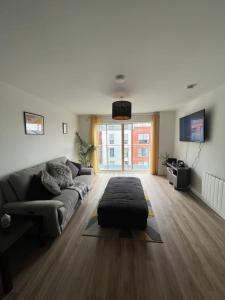 a living room with a couch and a large window at Belfast Luxury Apartment in Belfast