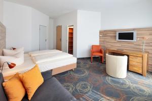 a hotel room with a bed and a desk and a couch at Petul Apart Hotel Residenz in Essen