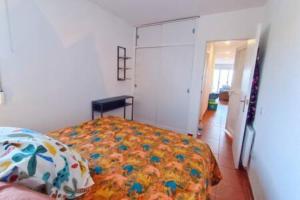 1 dormitorio con 1 cama con un edredón colorido en Apartment Sol Vinaròs con AA Wi-Fi a primera línea y vistas al mar., en Vinarós