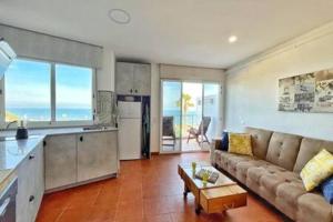 a living room with a couch and a kitchen at Apartment Sol Vinaròs con AA Wi-Fi a primera línea y vistas al mar. in Vinarós