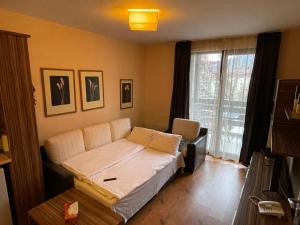 uma sala de estar com uma cama e uma janela em Lorena’s Apartment Bansko,near Gondola em Bansko