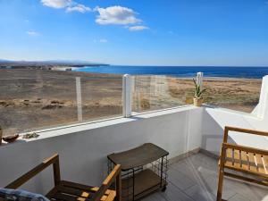 a balcony with chairs and a view of the ocean at Apartamentos Cotillo Family in Cotillo