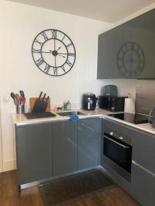 a kitchen with a large clock on the wall at JJ Luxury Apartment in London