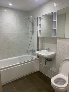 y baño con aseo, lavabo y ducha. en JJ Luxury Apartment, en Londres