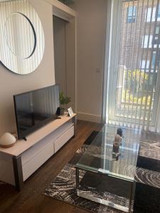 a living room with a tv and a glass table at JJ Luxury Apartment in London