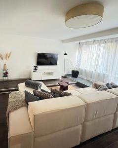 a living room with a white couch and a flat screen tv at Cozy Residence Sv. Duh in Zagreb