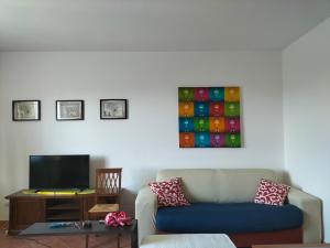ein Wohnzimmer mit einem Sofa und einem TV in der Unterkunft La Casa di Sofia - Casa Vacanza Monterosi in Monterosi