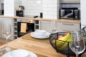 uma mesa de cozinha com uma taça de fruta e 2 copos de vinho em Luxury Two Bed Apartment with 55in TVs and Netflix em Headingley