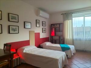 a hotel room with two beds and a window at La Casa di Sofia - Casa Vacanza Monterosi in Monterosi