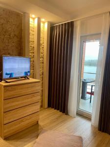 a room with a television on a dresser with a window at Casa Teo in Mahmudia