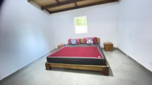 ein Schlafzimmer mit einem Bett mit einer roten Decke in der Unterkunft Harena Villa in Morondava