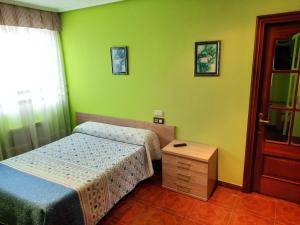 1 dormitorio con 2 camas y mesa de madera en Hotel Pedramea en A Coruña