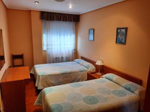 a hotel room with two beds and a window at Hotel Pedramea in A Coruña