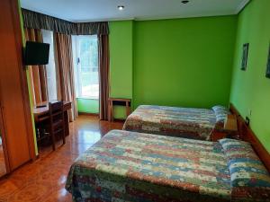 Habitación de hotel con 2 camas y paredes verdes en Hotel Pedramea en A Coruña