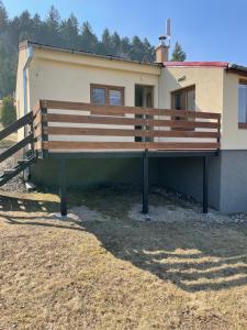 un banco de madera sentado frente a un edificio en Ubytování pod Stolovou en Kunčice pod Ondřejníkem