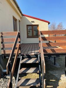 a wooden deck with two benches in front of a house at Ubytování pod Stolovou in Kunčice pod Ondřejníkem