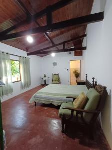 een slaapkamer met een bed en een stoel in een kamer bij Recanto da Tuca in Socorro