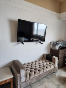a couch in a living room with a flat screen tv at Tropical Executive Hotel in Manaus