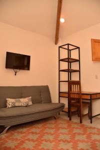 ein Wohnzimmer mit einem Sofa, einem Stuhl und einem Tisch in der Unterkunft Mansion Primavera in San Cristóbal de las Casas