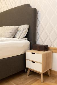 1 cama con mesita de noche de madera junto a una cama con un cajón en Luxury rooms 12-2, en Plovdiv