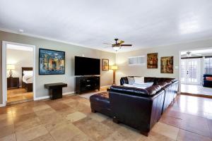 uma sala de estar com um sofá de couro e uma televisão de ecrã plano em Fortuitous - A Birdy Vacation Rental em San Antonio