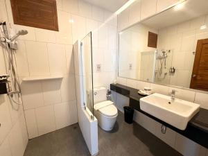 uma casa de banho branca com um WC e um lavatório em Choe Hotel Banbueng em Ban Bung