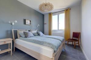 Un dormitorio con una cama grande y una silla. en L'Amphithéâtre des Volcans - Vue Puy de Dôme, en Saint-Genès-Champanelle 24 fotos más