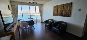 a living room with chairs and a table with a view at Nautilus Peninsula Piso 14 (Cerca de Todo) in Iquique