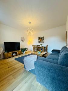 a living room with a blue couch and a tv at Attraktive Wohnung im grünen Hinterhof in Schwerin