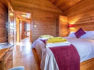 a bedroom with two beds in a log cabin at 2 Bed in Clovelly 00362 in Clovelly