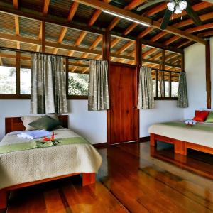 um quarto com 2 camas num quarto com pisos em madeira em Apu Napo Lodge & Reserve em Mondaña