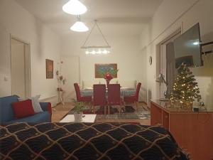 a living room with a table and a christmas tree at Smaragdas Paradise in Hydra
